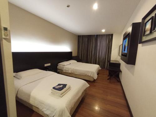 Habitación de hotel con 2 camas y TV en H-5 INN, en Bintulu