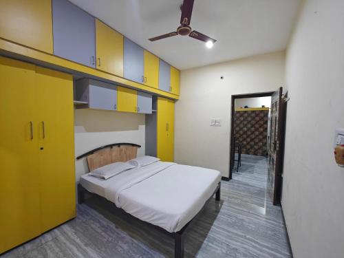 um quarto com uma cama com armários amarelos e azuis em 2Bhk holiday home em Mysore