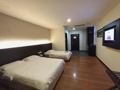Habitación de hotel con 2 camas y TV de pantalla plana. en H-5 INN, en Bintulu