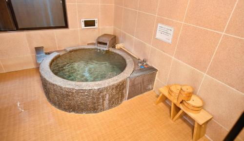 a bathroom with a large stone tub in a room at Kamegawa Onsen HATAGO Yuyu in Beppu