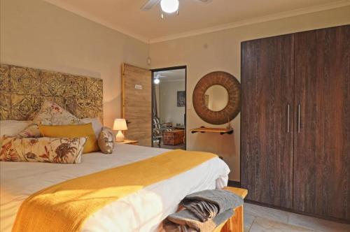 a bedroom with a large bed and a wooden cabinet at Adventure Bush Manor in Marloth Park