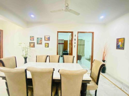 una sala da pranzo con tavolo e sedie bianchi di Luxurious Beautiful House Sector 70 noida a Noida
