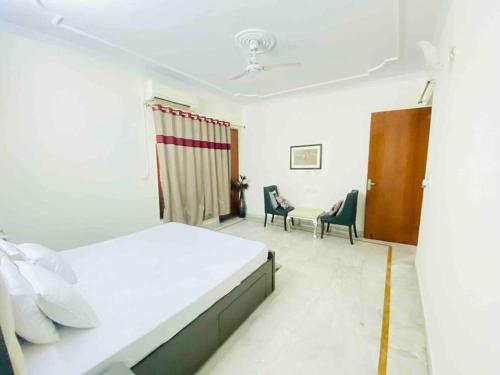 una camera con un letto e due sedie e un tavolo di Luxurious Beautiful House Sector 70 noida a Noida