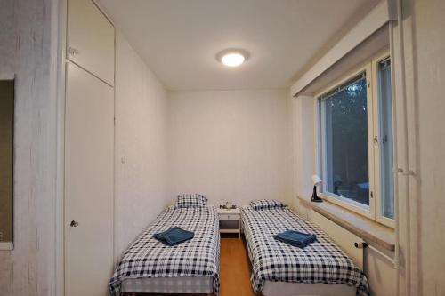 two beds in a room with a window at Yksiö lähellä Himosta. in Jämsä