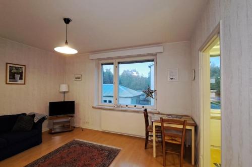 een woonkamer met een bank, een tafel en een raam bij Yksiö lähellä Himosta. in Jämsä