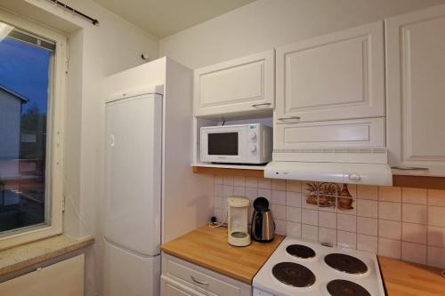 eine Küche mit weißen Schränken und einer weißen Mikrowelle in der Unterkunft Yksiö lähellä Himosta. in Jämsä