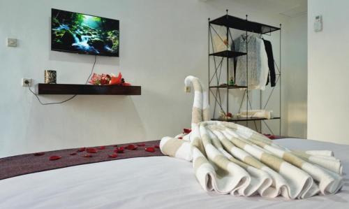 um cisne feito de toalhas numa cama em Balian Surf Club em Legian
