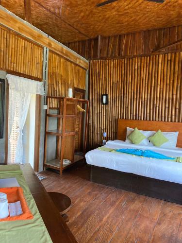 a bedroom with a bed and a wooden wall at Gading Tree House in Nusa Penida