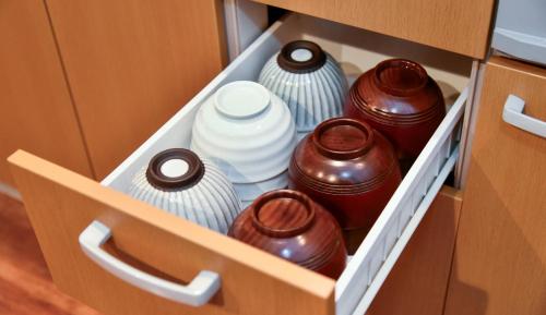 a drawer with vases and plates in a cabinet at Resort Yufuin - Grandpia Resort Yufuin in Yufuin