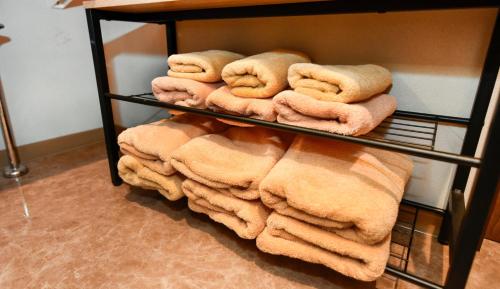 a pile of towels on a shelf in a bathroom at Resort Yufuin - Grandpia Resort Yufuin in Yufuin