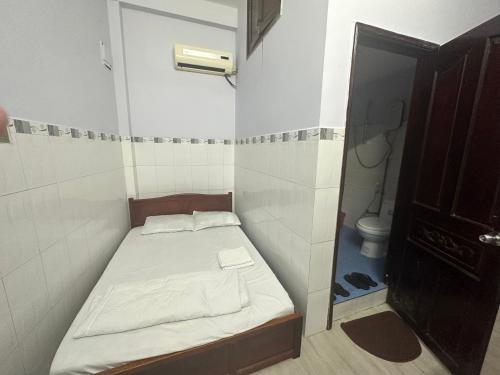 een kleine kamer met een klein bed en een toilet bij Phòng cho thuê Minh Phương in Ho Chi Minh-stad
