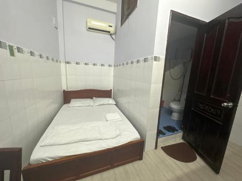 een kleine slaapkamer met een bed en een toilet bij Phòng cho thuê Minh Phương in Ho Chi Minh-stad
