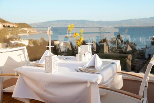 a white table and chairs with a view of the water at Bellazure Hotel in Akyarlar