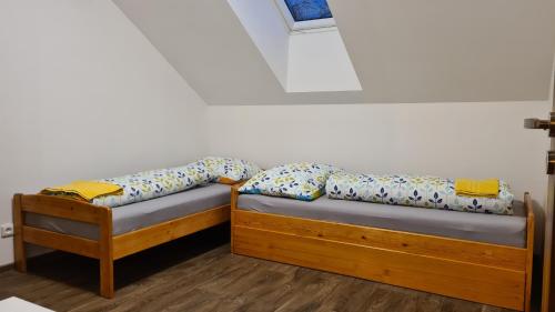 two twin beds in a room with a window at Apartmán Malá Valaška in Ratiboř