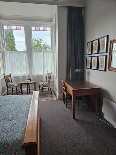 uma sala de estar com mesa de pingue-pongue e cadeiras em The Villa em Oamaru