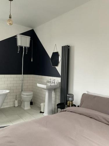 a bedroom with a bed and a sink and a toilet at Entire boutique mill cottage in Elland