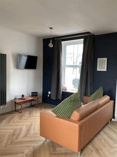 a living room with a couch and a window at Entire boutique mill cottage in Elland