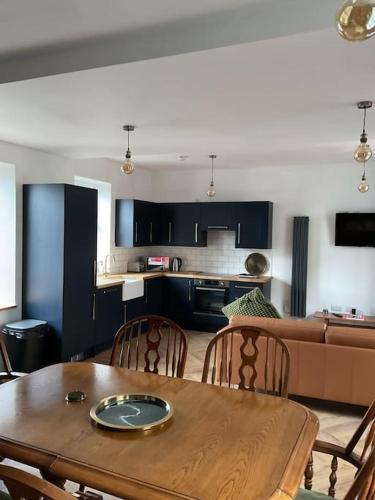 a kitchen and dining room with a wooden table and chairs at Entire boutique mill cottage in Elland