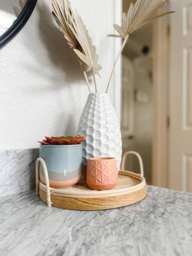 a wooden tray with two pots and a vase on it at BOHO House - Pool, Spa, Boat Parking, Central in Lake Havasu City