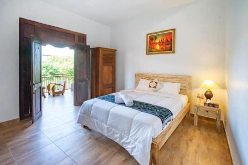 a bedroom with a large white bed and a window at Pondok Kita in Canggu