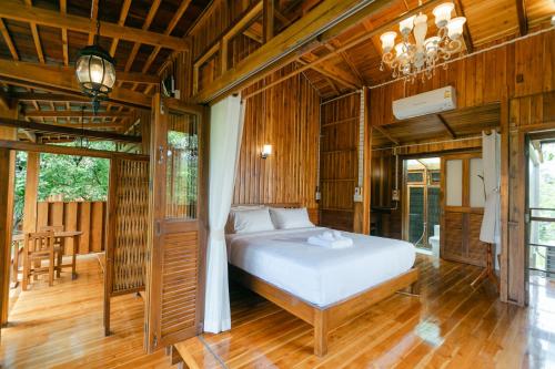 a bedroom with a bed in a room with wooden floors at Saksila Resort in Nan