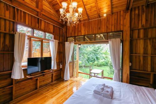 a bedroom with a bed and a flat screen tv at Saksila Resort in Nan