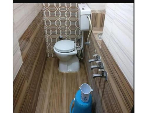 a bathroom with a white toilet in a room at Hotel Sanginee, Maheshwar in Maheshwar