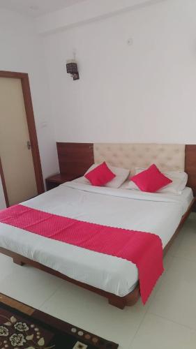 a bedroom with a large bed with red pillows at PPH Living B S K in Bengaluru