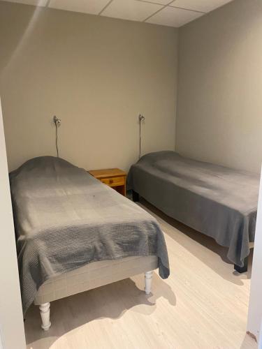 a bedroom with two beds and a nightstand and sidx sidx sidx sidx at Rosendal Apartments Motellet in Rosendal