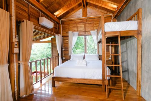 a bedroom with a bunk bed and a balcony at Saksila Resort in Nan