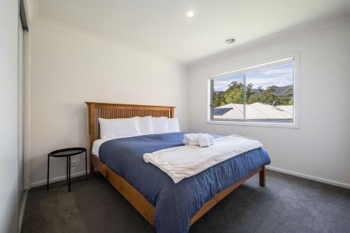 Un dormitorio con una cama grande con ventana. en Mountain Bike Haven, en Bright