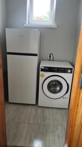 a white refrigerator and a washing machine in a kitchen at Polna 40 in Zduny