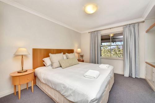 um quarto com uma cama grande e uma janela em Villa 2br Madeira Villa located within Cypress Lakes Resort em Pokolbin