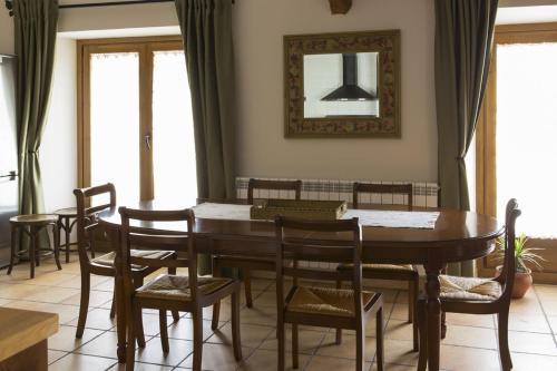 een eetkamer met een houten tafel en stoelen bij El Trujal de las Bardenas in Cabanillas