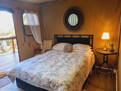 1 dormitorio con cama, mesa y espejo en Birdsong Retreat BnB on Lamb Island, 