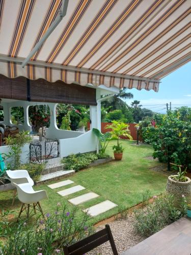 a garden with a pergola and a lawn at Reef Hills Residence LUXURY VILLA in Anse aux Pins