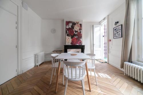 a dining room with a white table and chairs at Résidence Aristide Briand - Appartements en Centre Ville in Vichy
