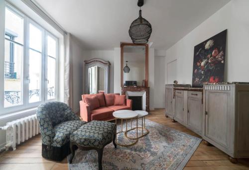 a living room with a couch and a chair at Résidence Aristide Briand - Appartements en Centre Ville in Vichy