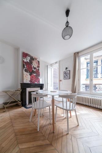 a living room with a table and chairs and a piano at Résidence Aristide Briand - Appartements en Centre Ville in Vichy