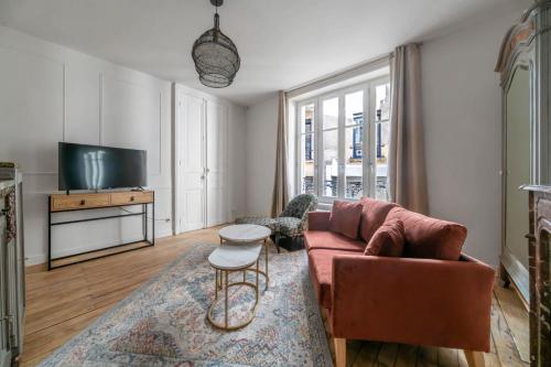 a living room with a couch and a tv at Résidence Aristide Briand - Appartements en Centre Ville in Vichy