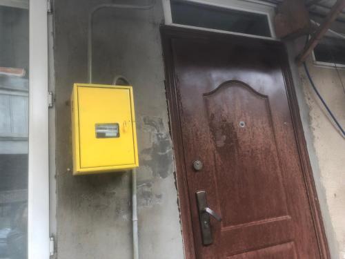 une boîte aux lettres jaune à côté d'une porte dans l'établissement Ritsa apartment, à Tbilissi