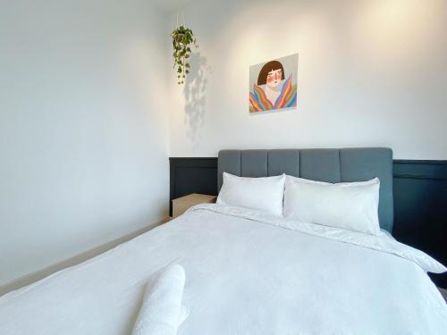 a bedroom with a large bed with white sheets at Arte Plus Ampang in Kuala Lumpur