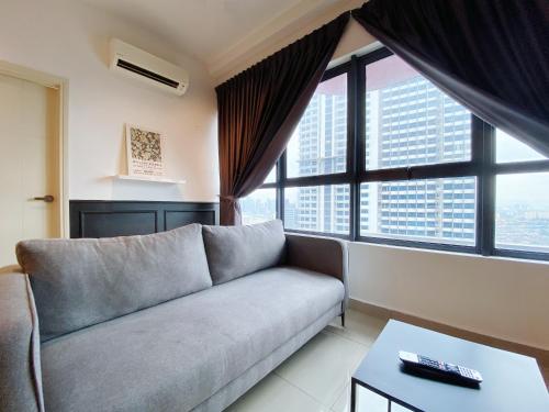 a living room with a couch and large windows at Arte Plus Ampang in Kuala Lumpur
