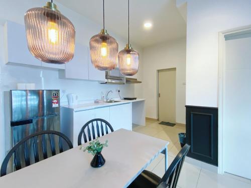 a kitchen with a table and chairs and pendant lights at Arte Plus Ampang in Kuala Lumpur