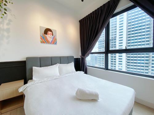 um quarto com uma grande cama branca e janelas grandes em Arte Plus Ampang em Kuala Lumpur