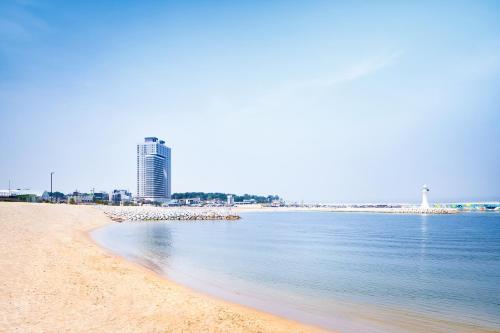 a view of a beach with a city in the background at Gangneung Chonpines Ocean Suites Hotel in Gangneung