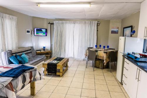 a living room with a couch a table and a refrigerator at Stamvrug 9 B in Nelspruit