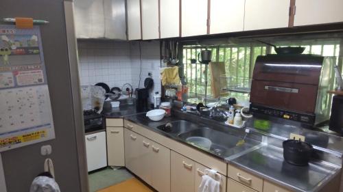 a kitchen with a sink and a counter top at Guesthouse Oomiya base 大宮基地別荘 in Chiba