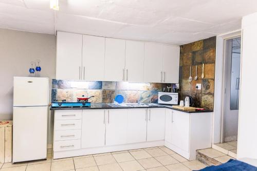 a kitchen with white cabinets and a refrigerator at Stamvrug 9 B in Nelspruit