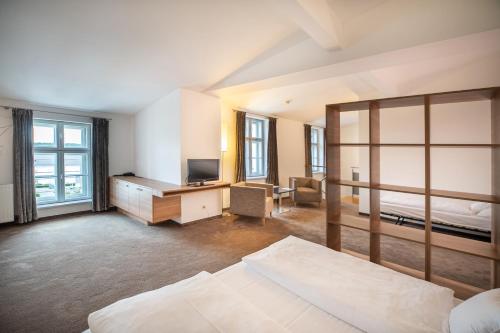 a bedroom with a bed and a desk with a television at Hotel Altes Kloster in Hainburg an der Donau